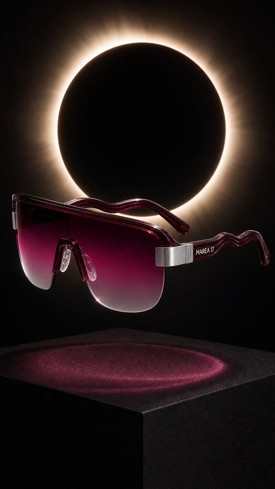Gafas MAREA 17 color vino suspendidas frente a un eclipse.